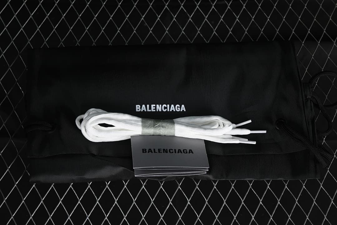 White spare laces and printed shoe accessories displayed with a black branded dust bag.