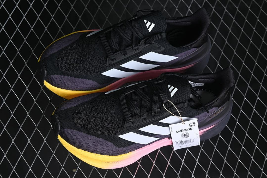 Pair of black and purple Ultraboost 5X shoes with white stripes and pink and yellow midsole accents.