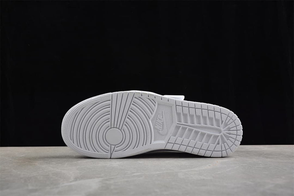Underside of the white sneaker showing the patterned outsole