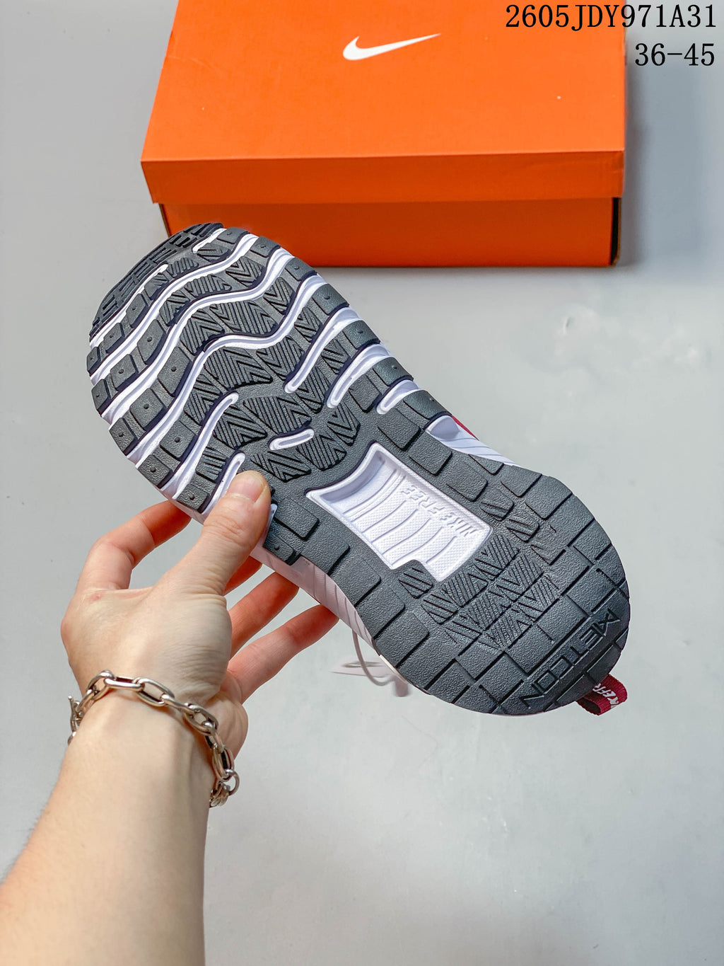 Underside of a Nike Free Metcon 6 shoe showing its dark patterned outsole and white grooves