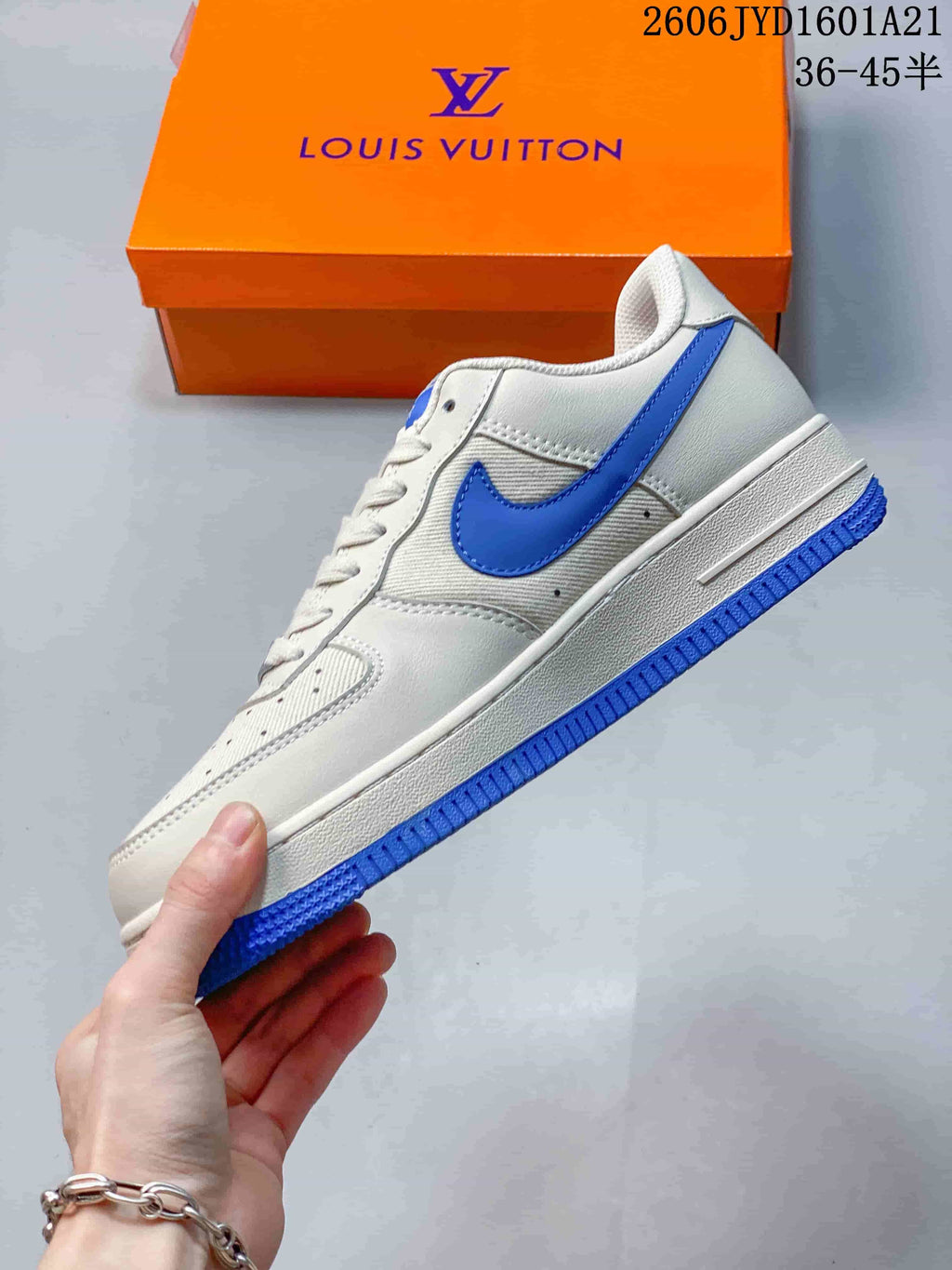 Side view of a white low-top sneaker with a blue Swoosh and blue outsole