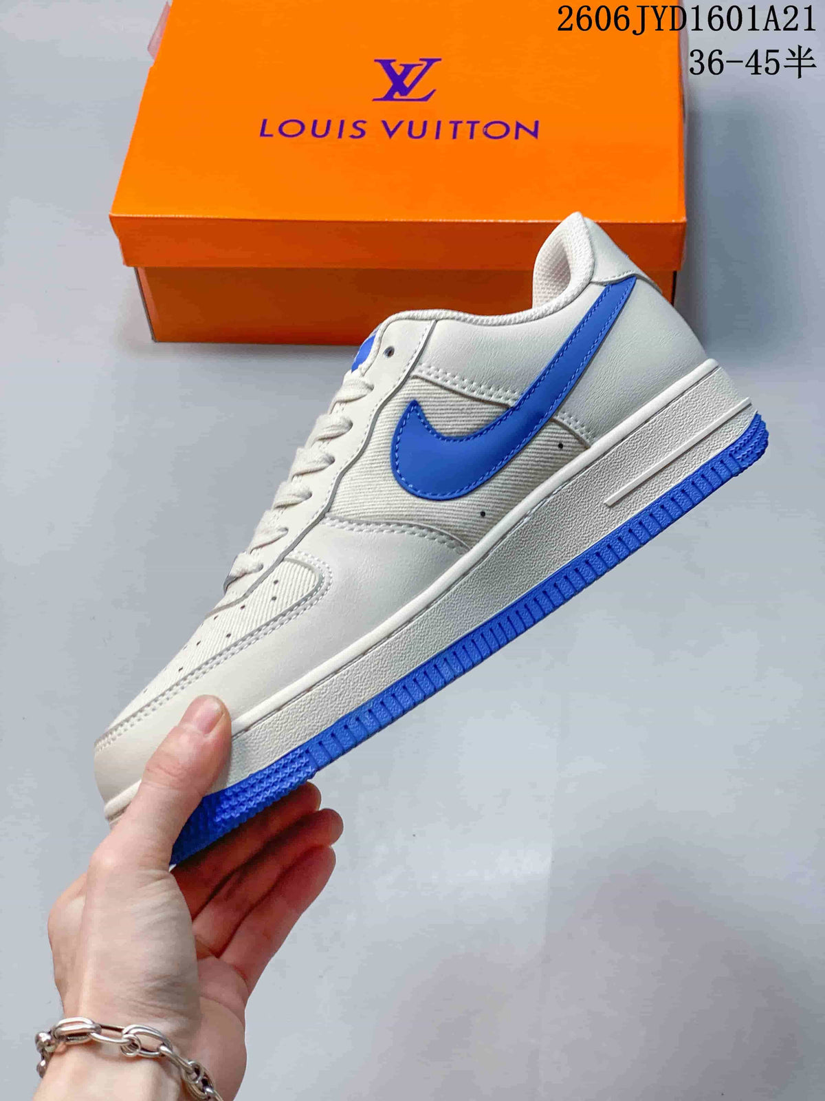 Side view of a white low-top sneaker with a blue Swoosh and blue outsole