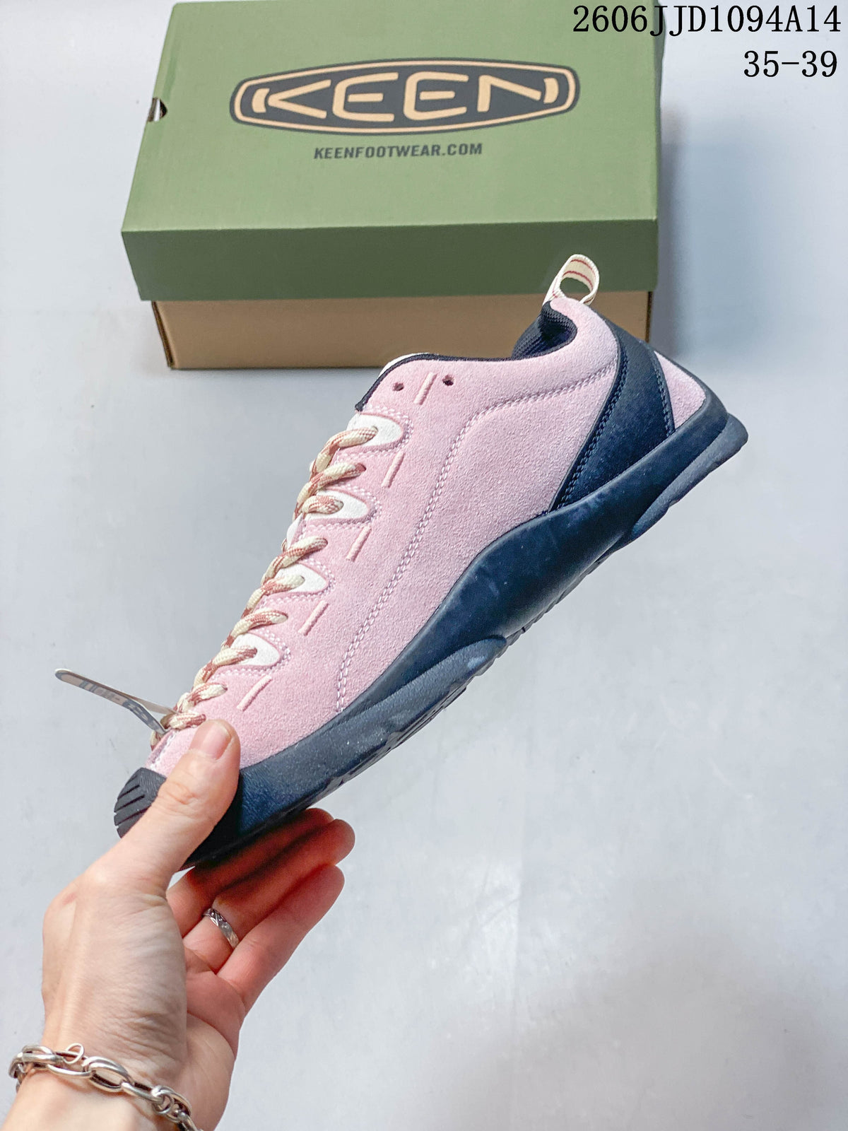 Side profile of the pink low-top sneaker with dark sole and heel accents