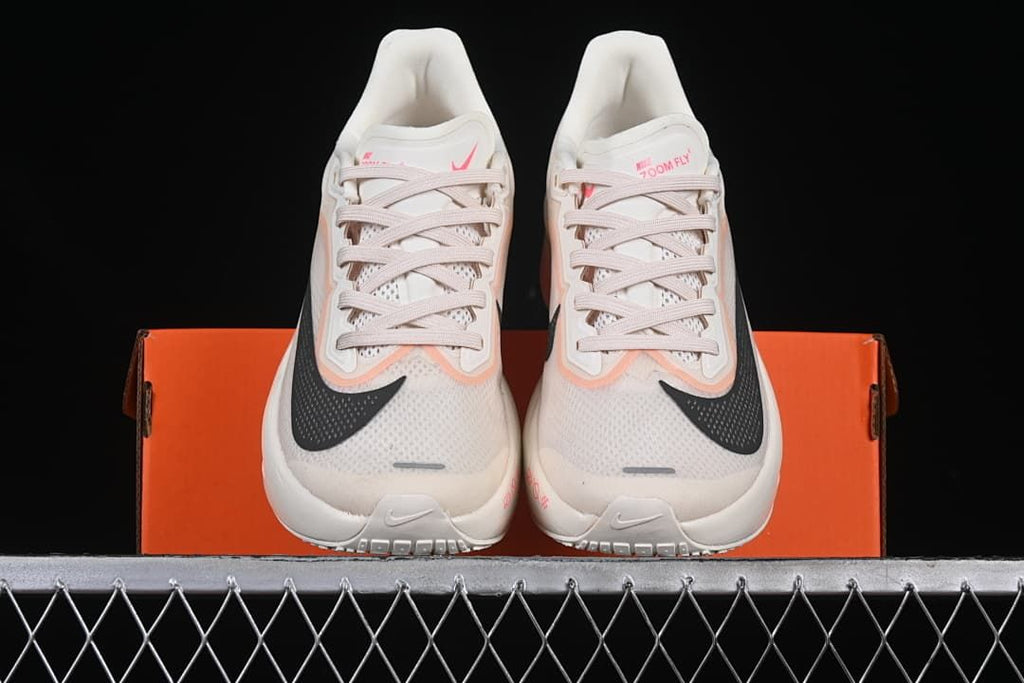 Front view of the pair of white running shoes with pink and black accents