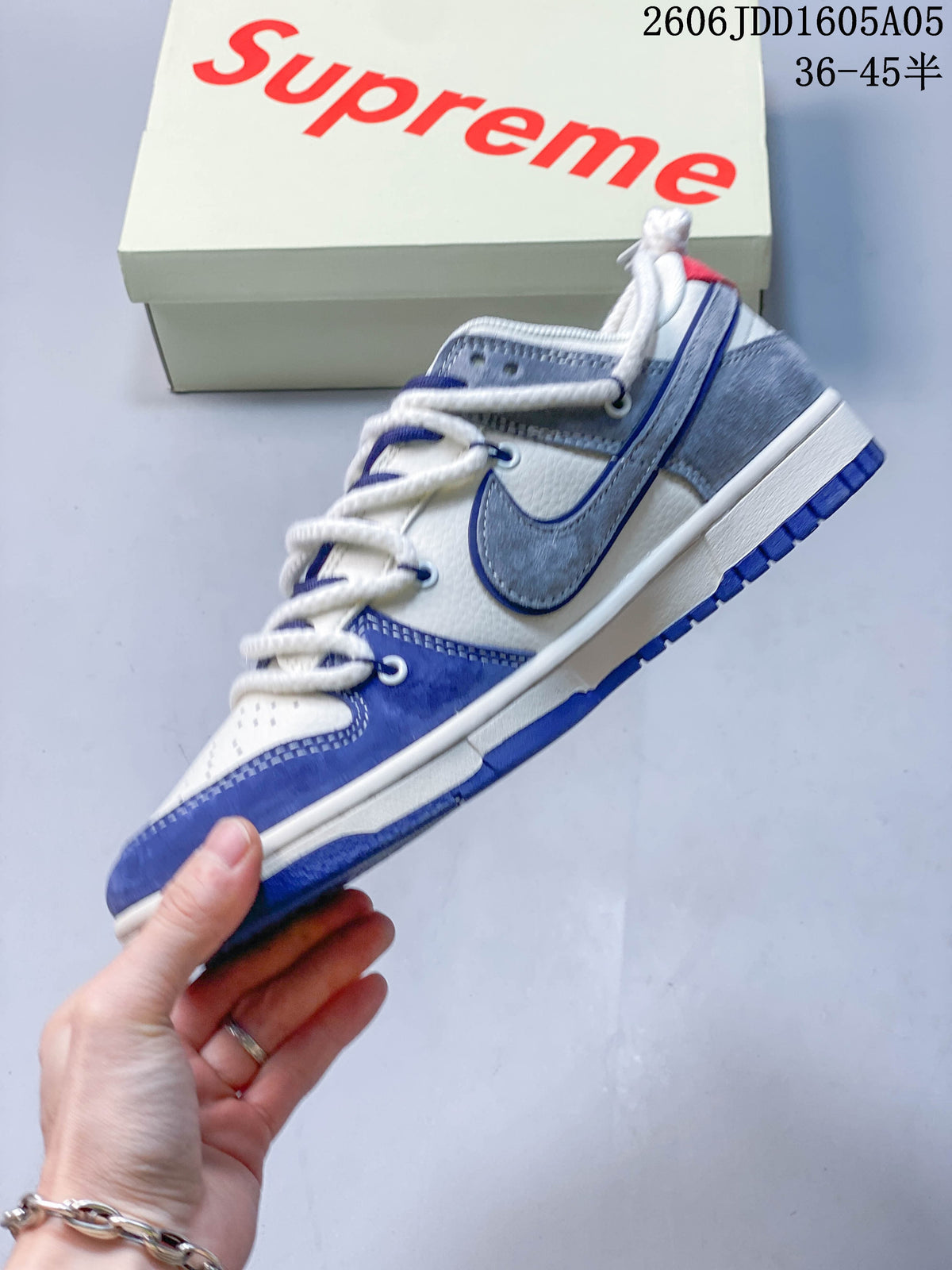 Side profile of a white, blue, and gray low-top sneaker with layered panels and cord laces