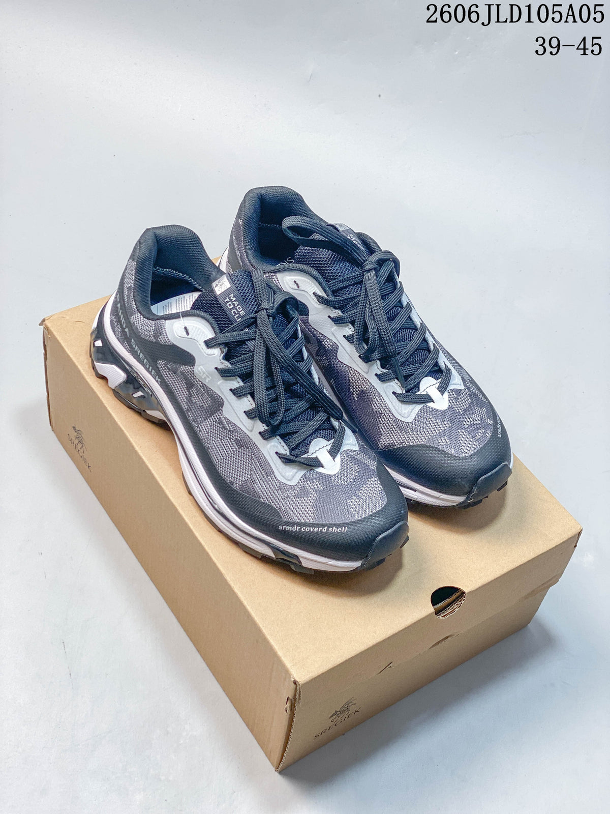 Pair of gray and navy SREGIEK trail sneakers displayed on a box.