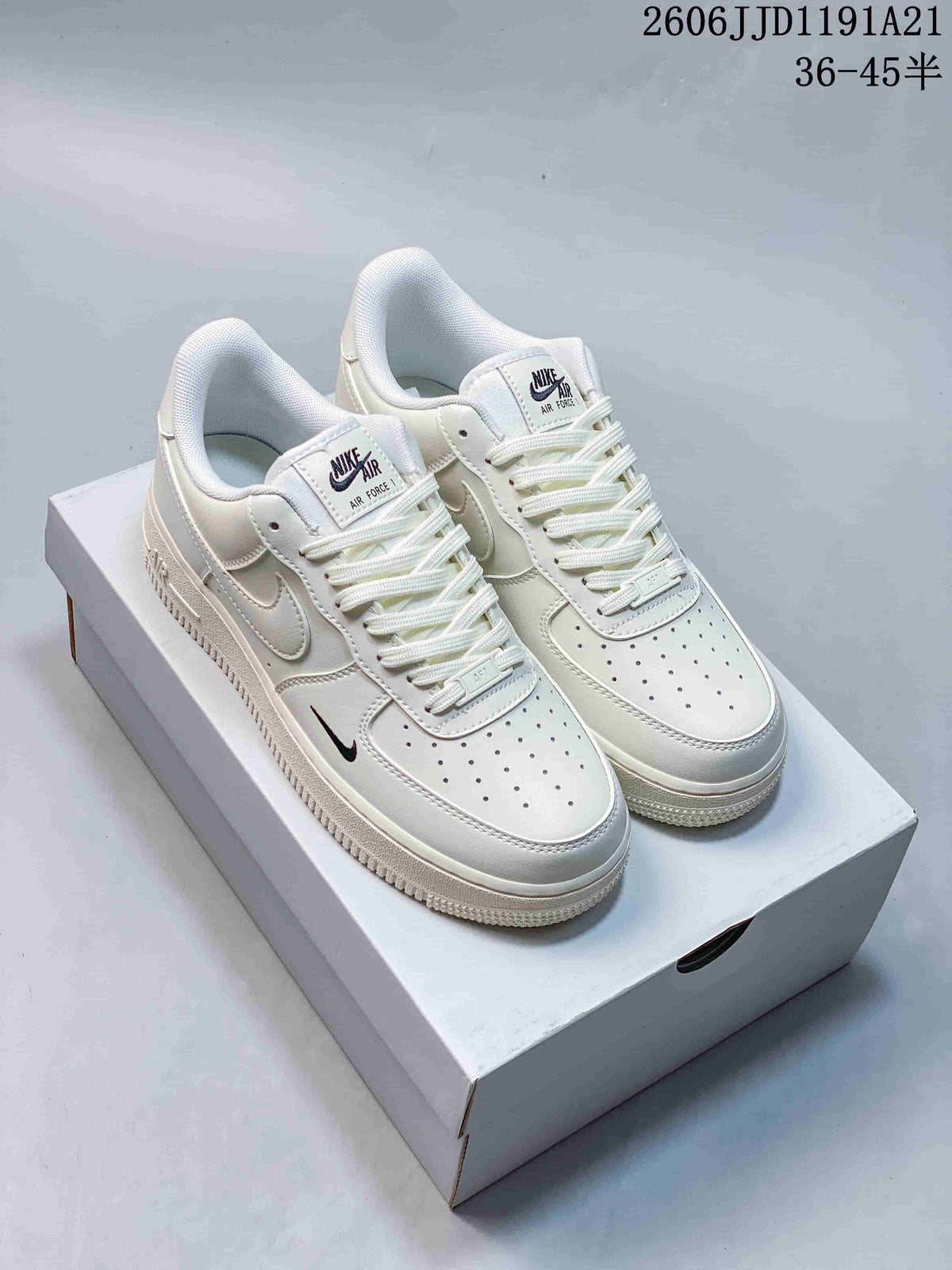 Pair of white Nike Air Force 1 low-top sneakers with small black forefoot accents, pictured on a white box