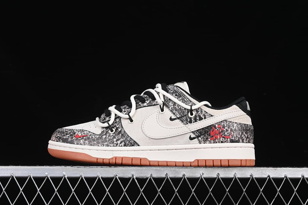 Side view of a white and black patterned low-top sneaker with red accents and gum-colored outsole