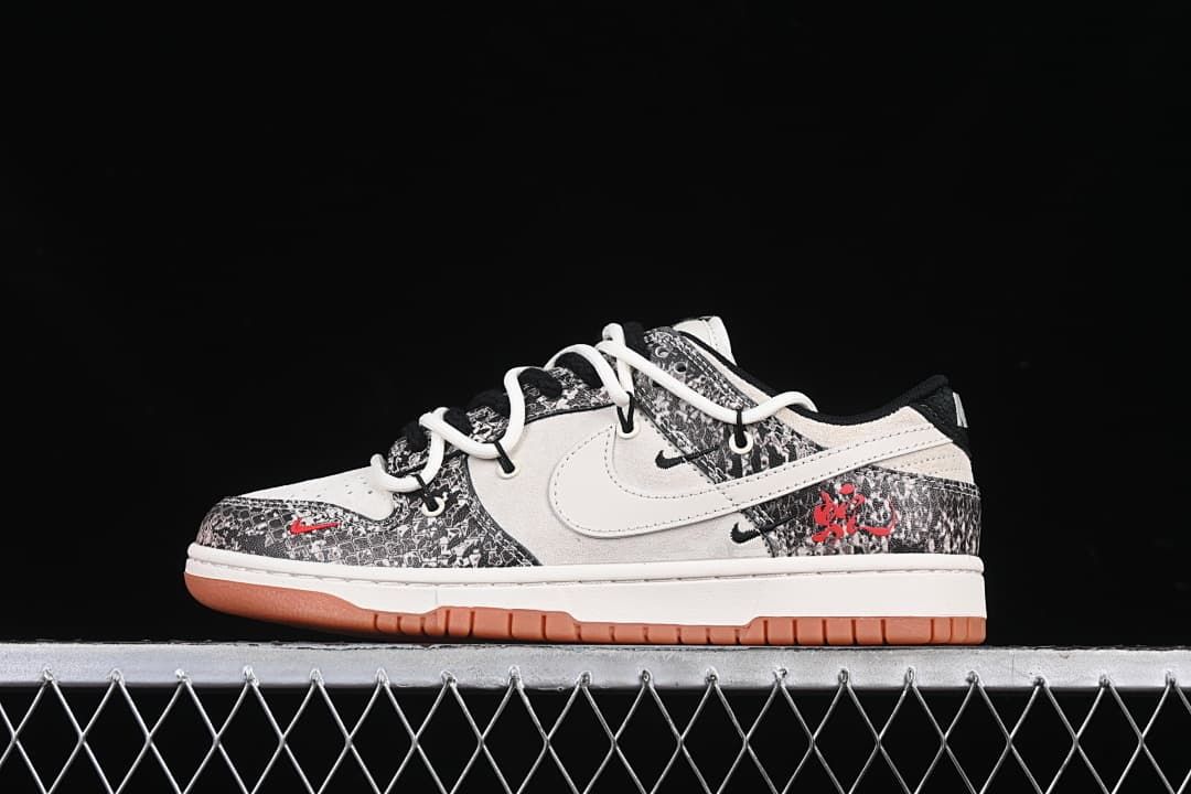 Side view of a white and black patterned low-top sneaker with red accents and gum-colored outsole