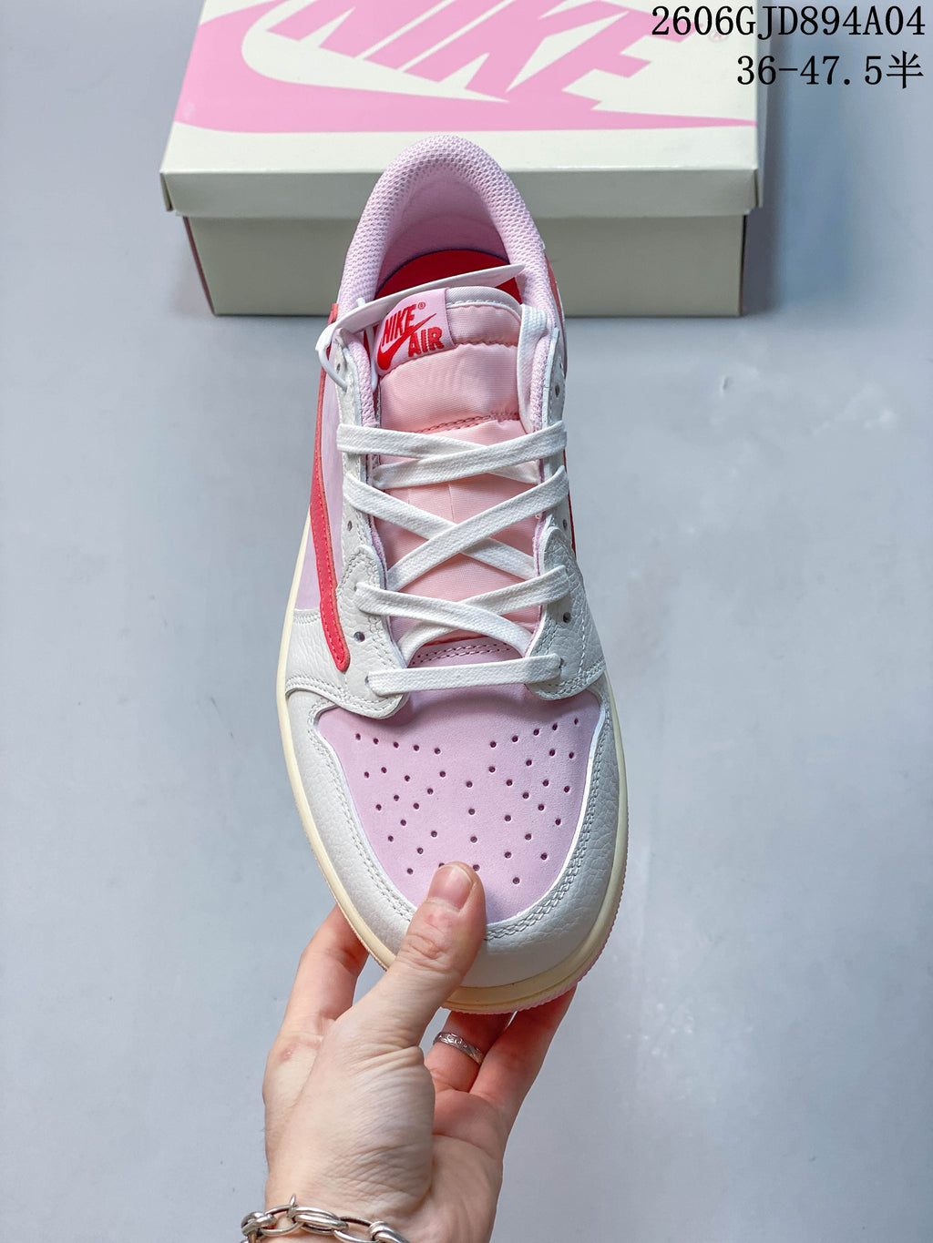 Top view of the sneaker showing white laces and a perforated pink toe