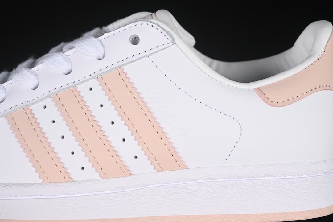 Close-up of the white side panel, blush-pink stripes, perforations, and heel accent.