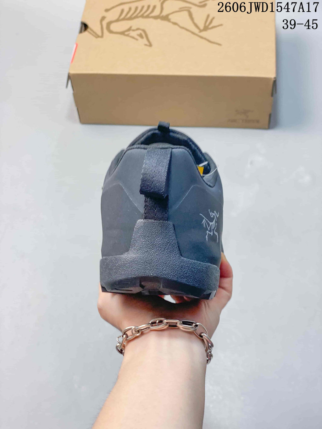 Rear view showing the heel and pull tab of the dark gray shoe.