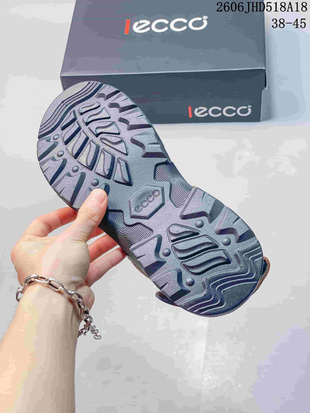 Close-up of the patterned outsole on a brown and gray sandal.
