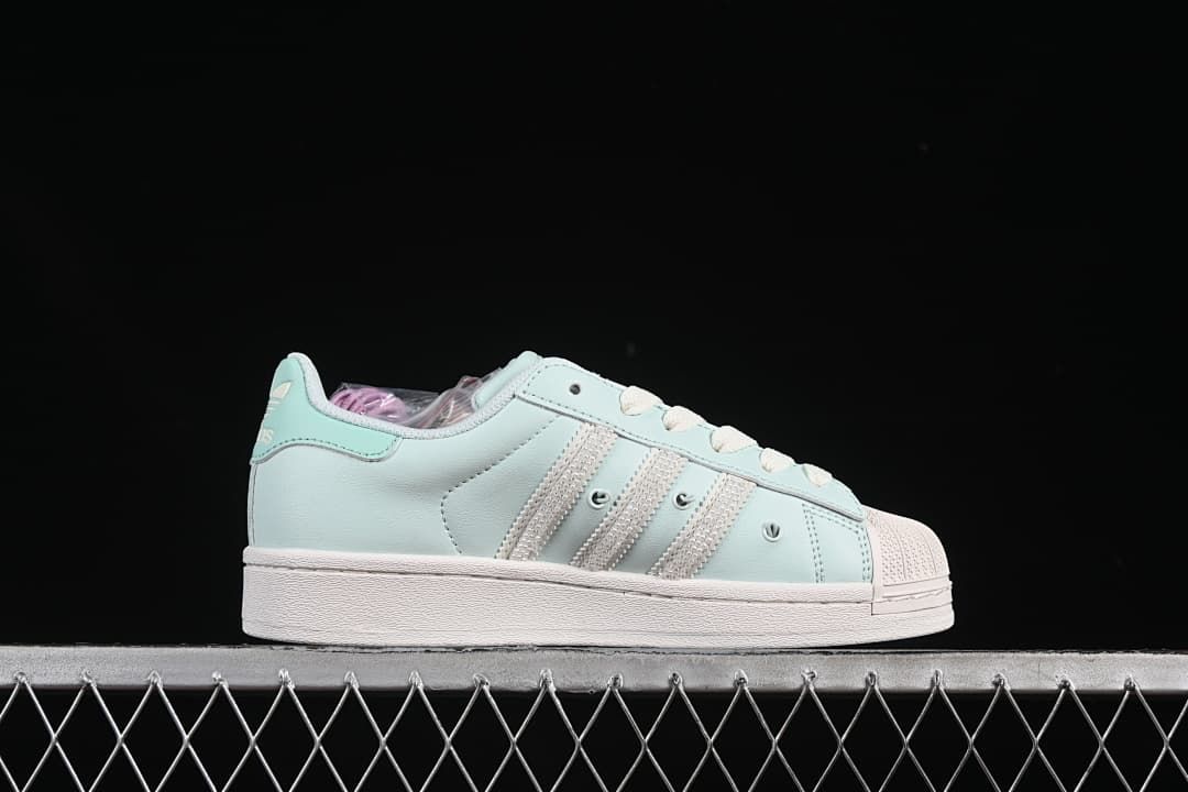 Side profile showing the mint upper, three stripes, and white sole