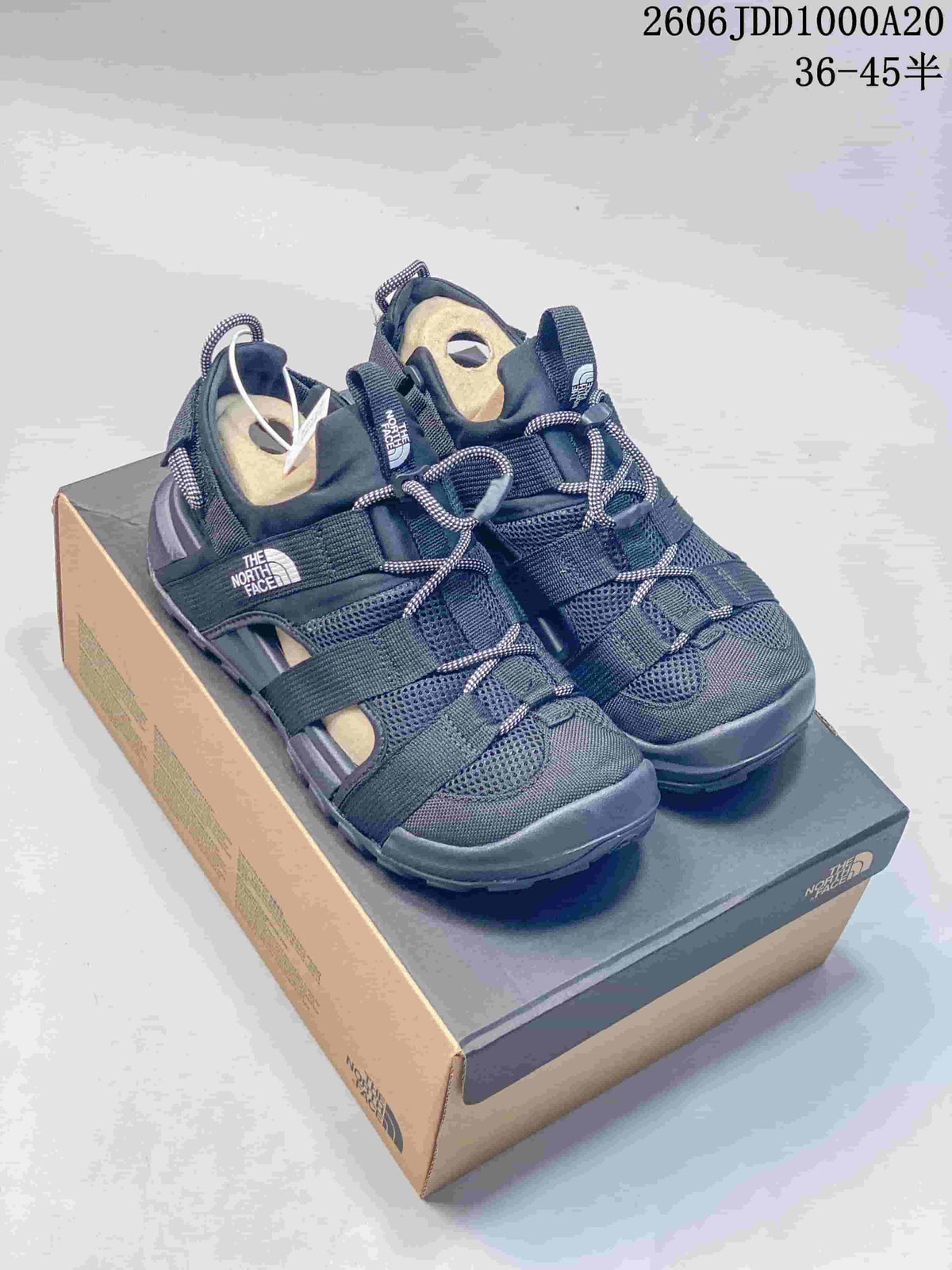 Pair of dark navy and gray The North Face Cedar Measa sandals on a shoebox