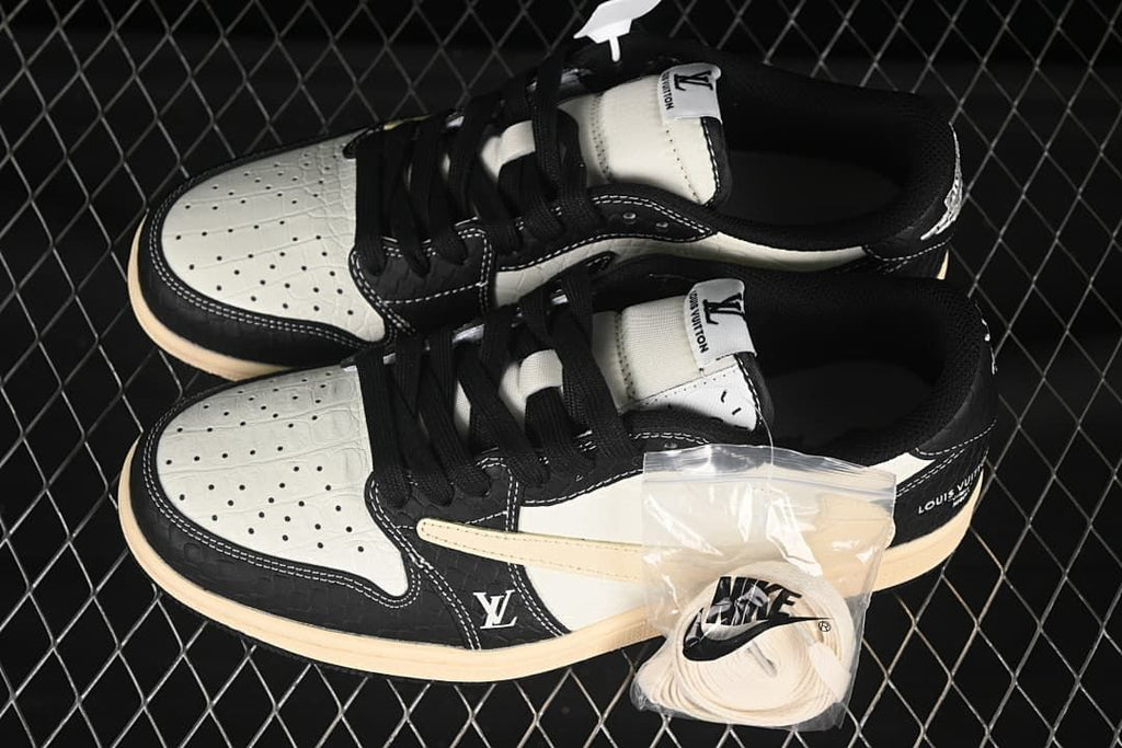 Overhead view of a pair of black and cream low-top sneakers with perforated toe panels and a spare set of light-colored laces.