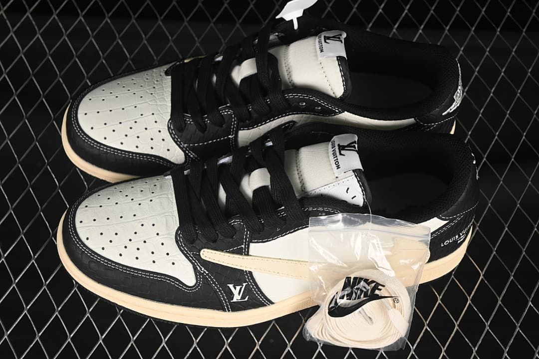 Overhead view of a pair of black and cream low-top sneakers with perforated toe panels and a spare set of light-colored laces.
