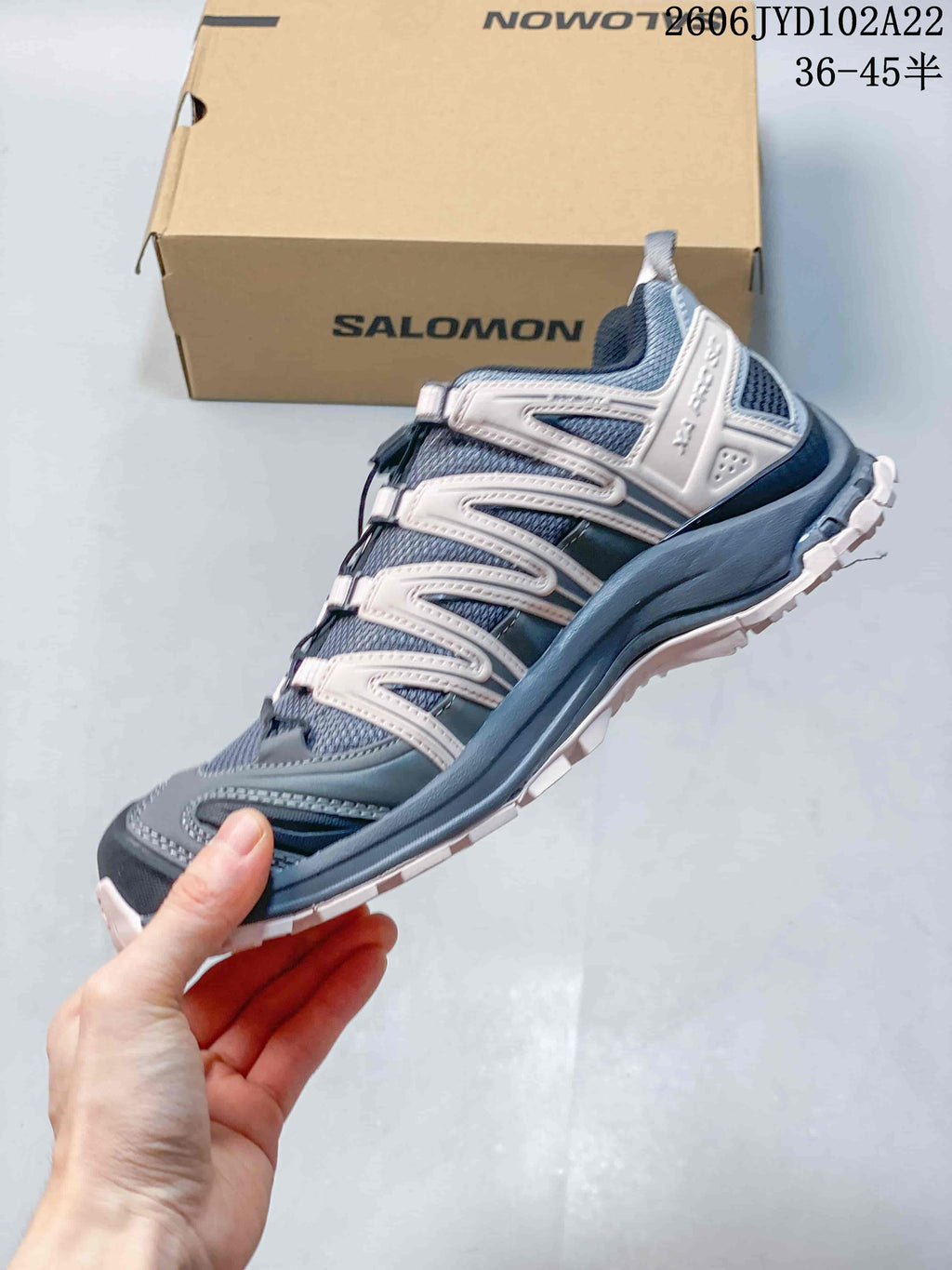 Side view of a gray and pale pink Salomon XA Pro 3D shoe