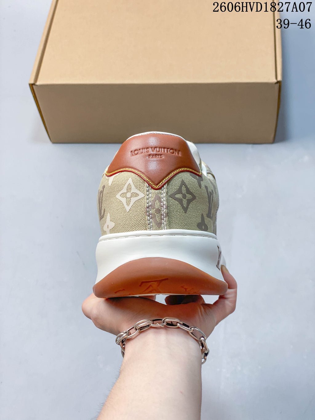 Rear view of the sneaker with a brown heel tab and beige monogram-patterned upper.