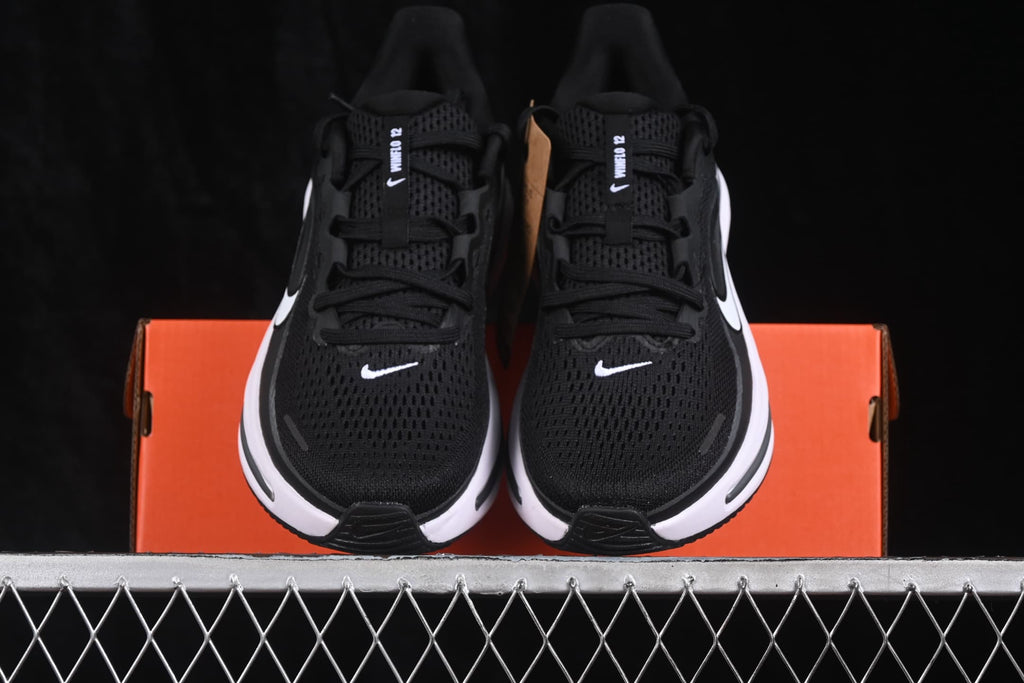 Front view of the black Nike Zoom Winflo 12 sneakers with white swoosh logos and white midsoles.