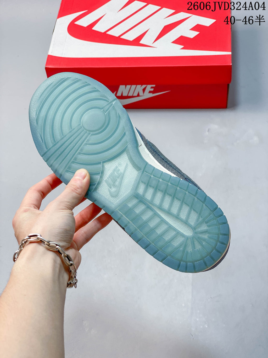 Translucent blue outsole of a gray and blue Nike Dunk Retro SE sneaker