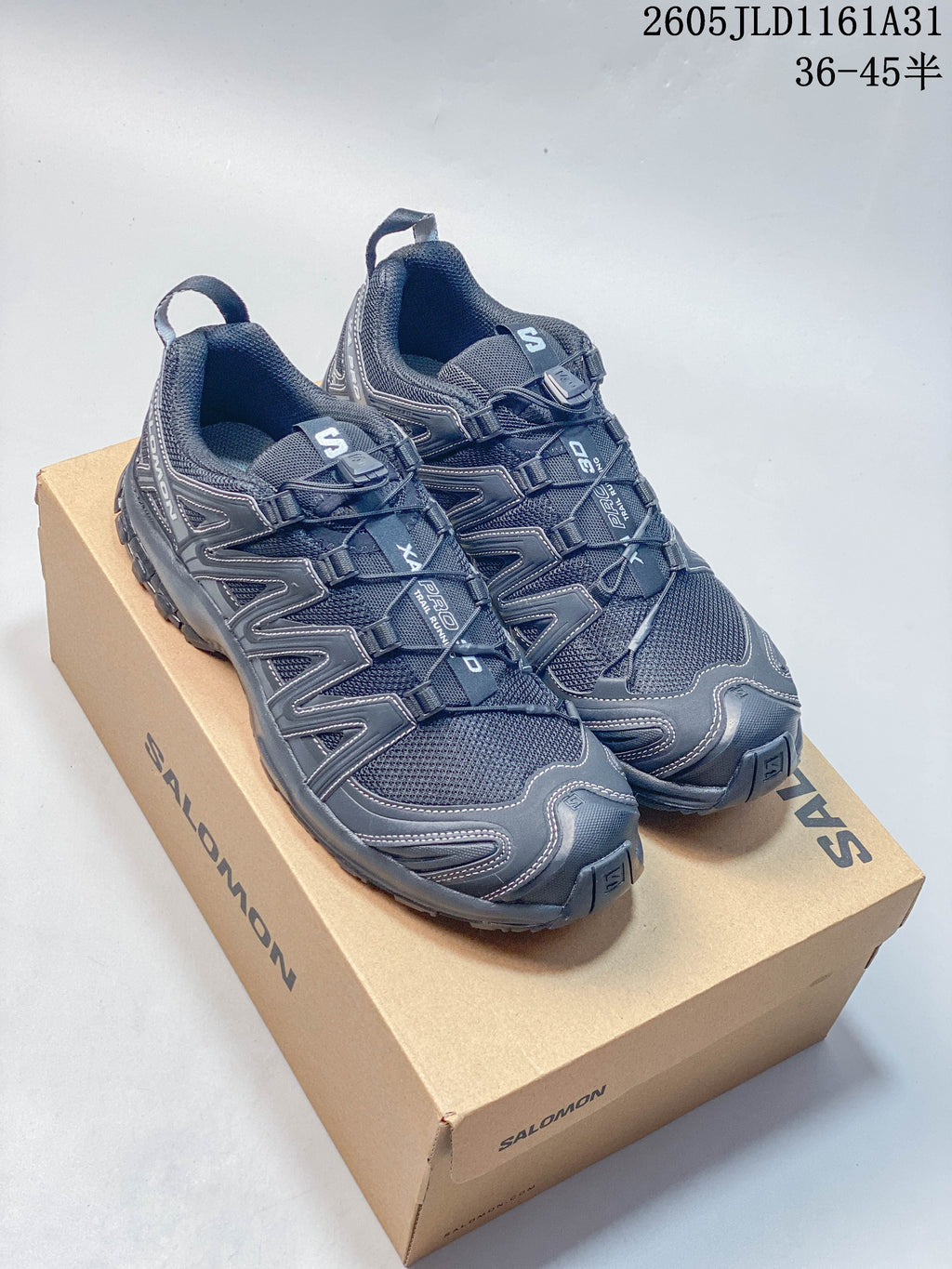 Pair of dark gray Salomon XA Pro 3D sneakers on a branded box.