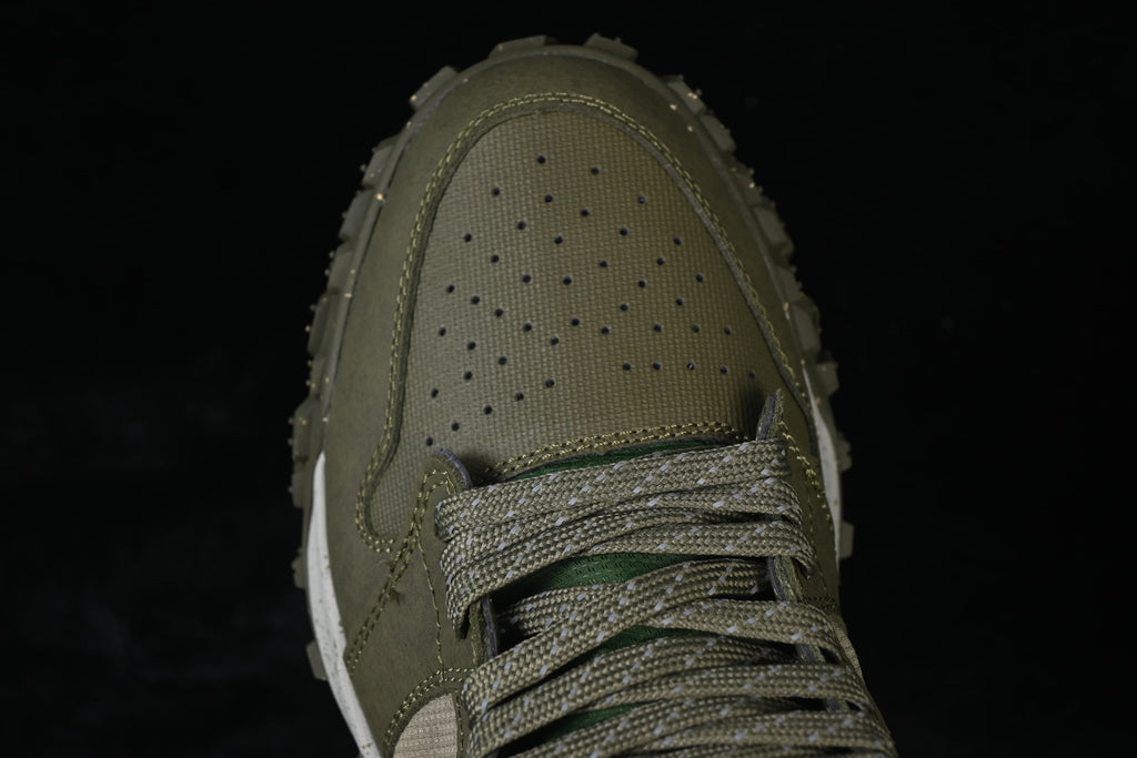 Close-up of the perforated olive toe and patterned laces.