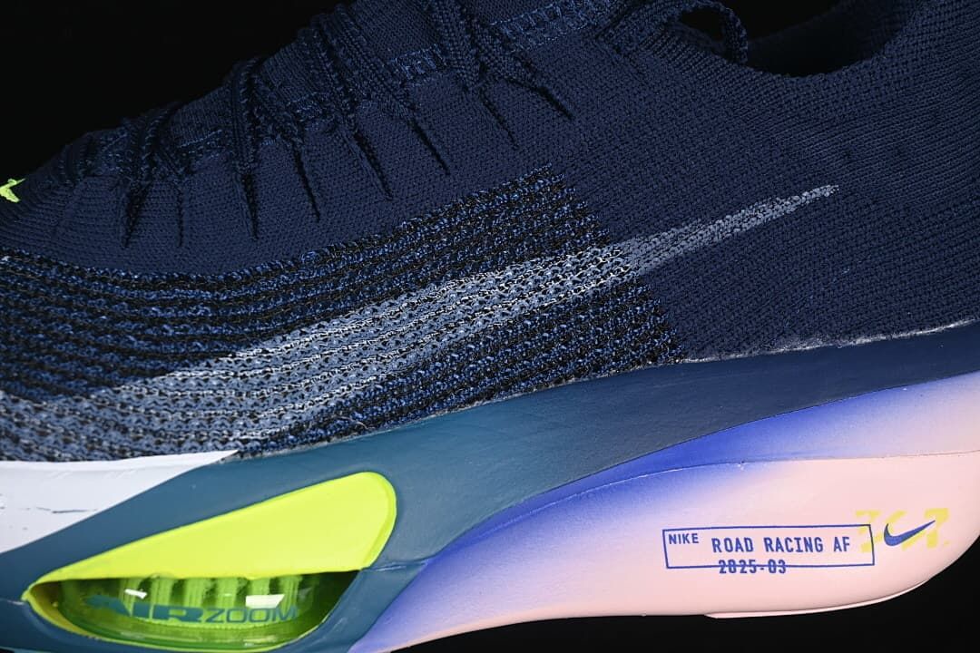 Close-up of the side swoosh, navy upper, and lime cushioning detail.