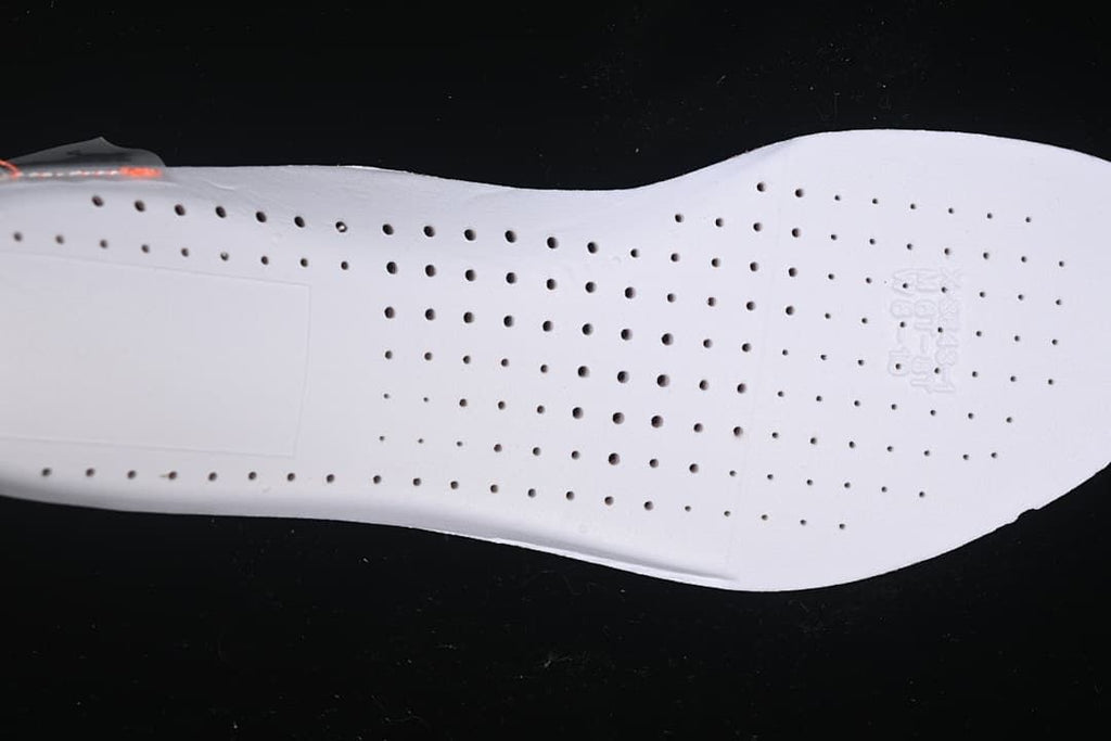 Close-up of the white shoe outsole with rows of circular perforations