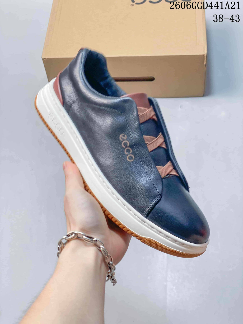 Angled side view of a navy ECCO sneaker with brown accents and a white midsole.