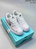 Pair of white Nike Court Vision Low sneakers with dark logos and custom-style graphic accents, shown on a turquoise box.