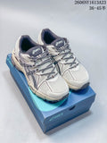 Pair of cream and navy ASICS Gel-Kahana 8 shoes displayed on a blue box