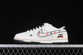 White low-top sneaker with black laces, red accents, playing-card graphics, and Stüssy-style branding, shown in profile.