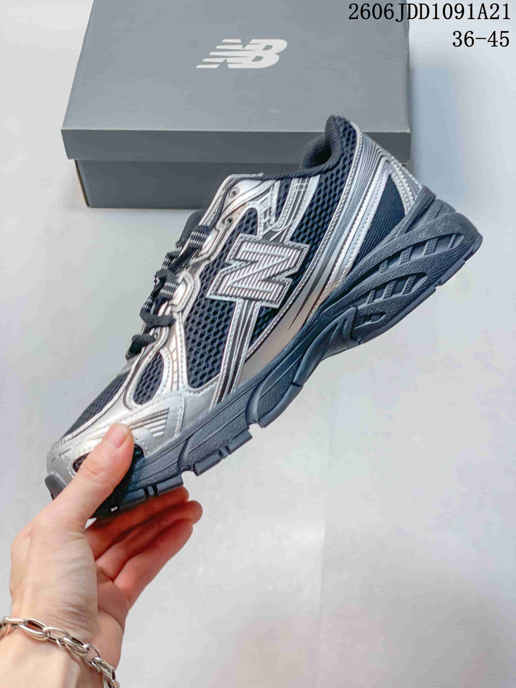 Side profile of a New Balance 740 sneaker with navy mesh and silver-toned overlays