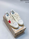 Pair of white low-top sneakers with red side stars and glittery pink heel panels, displayed on a shoebox.