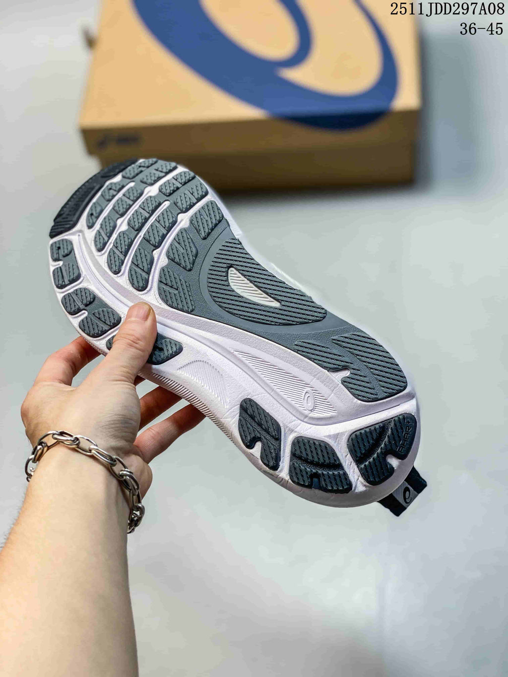 Close view of the dark gray shoe outsole with segmented tread and a white midsole.
