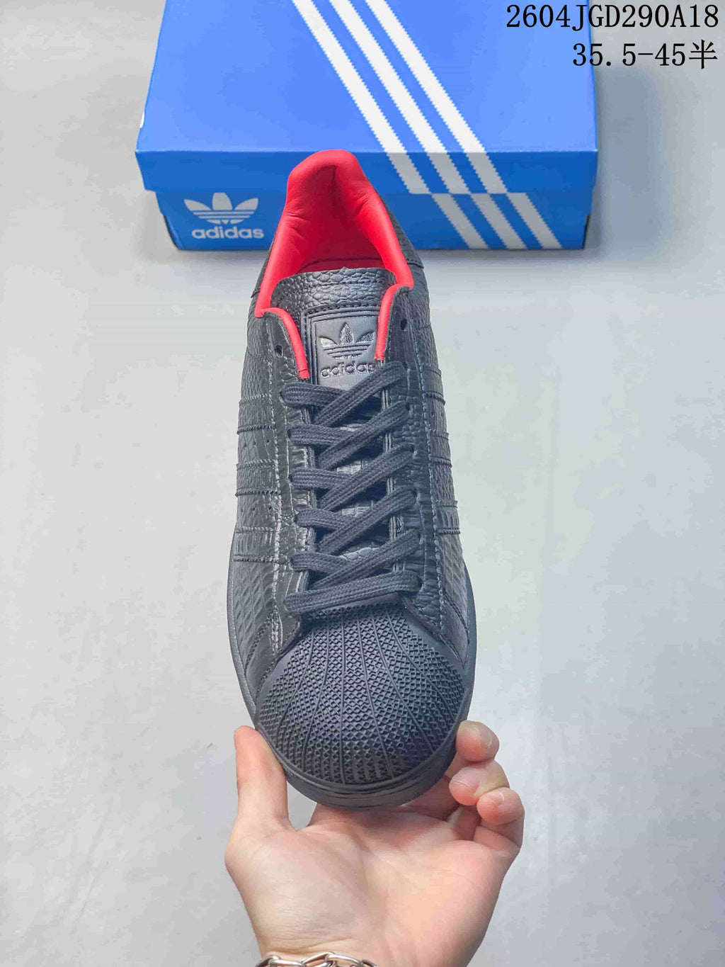 Front view showing the shell toe and red lining of a black Superstar 2 sneaker