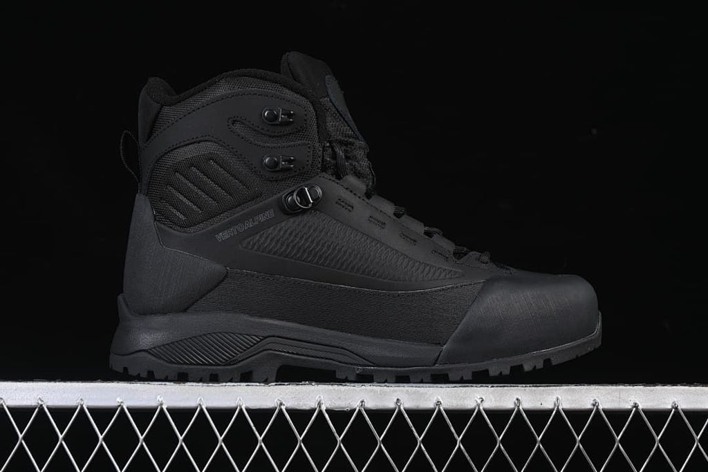 Side profile of a black Verto Alpine mid boot with speed hooks and a lugged sole.