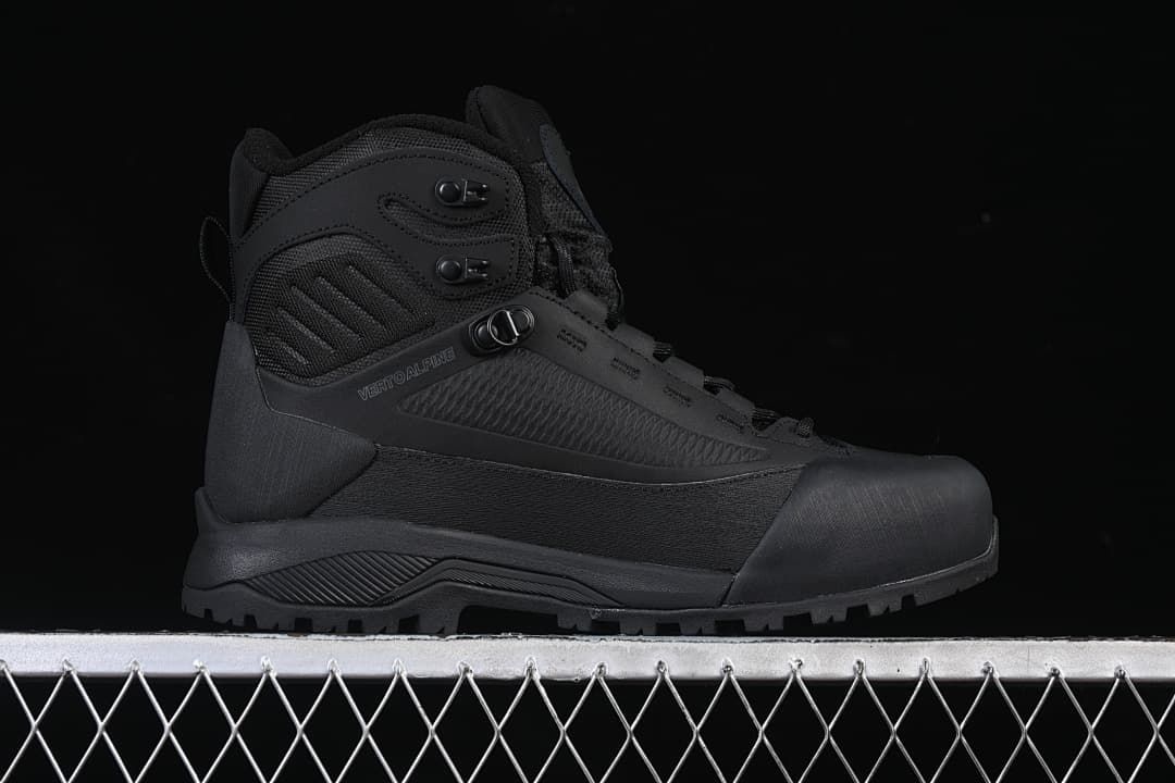 Side profile of a black Verto Alpine mid boot with speed hooks and a lugged sole.