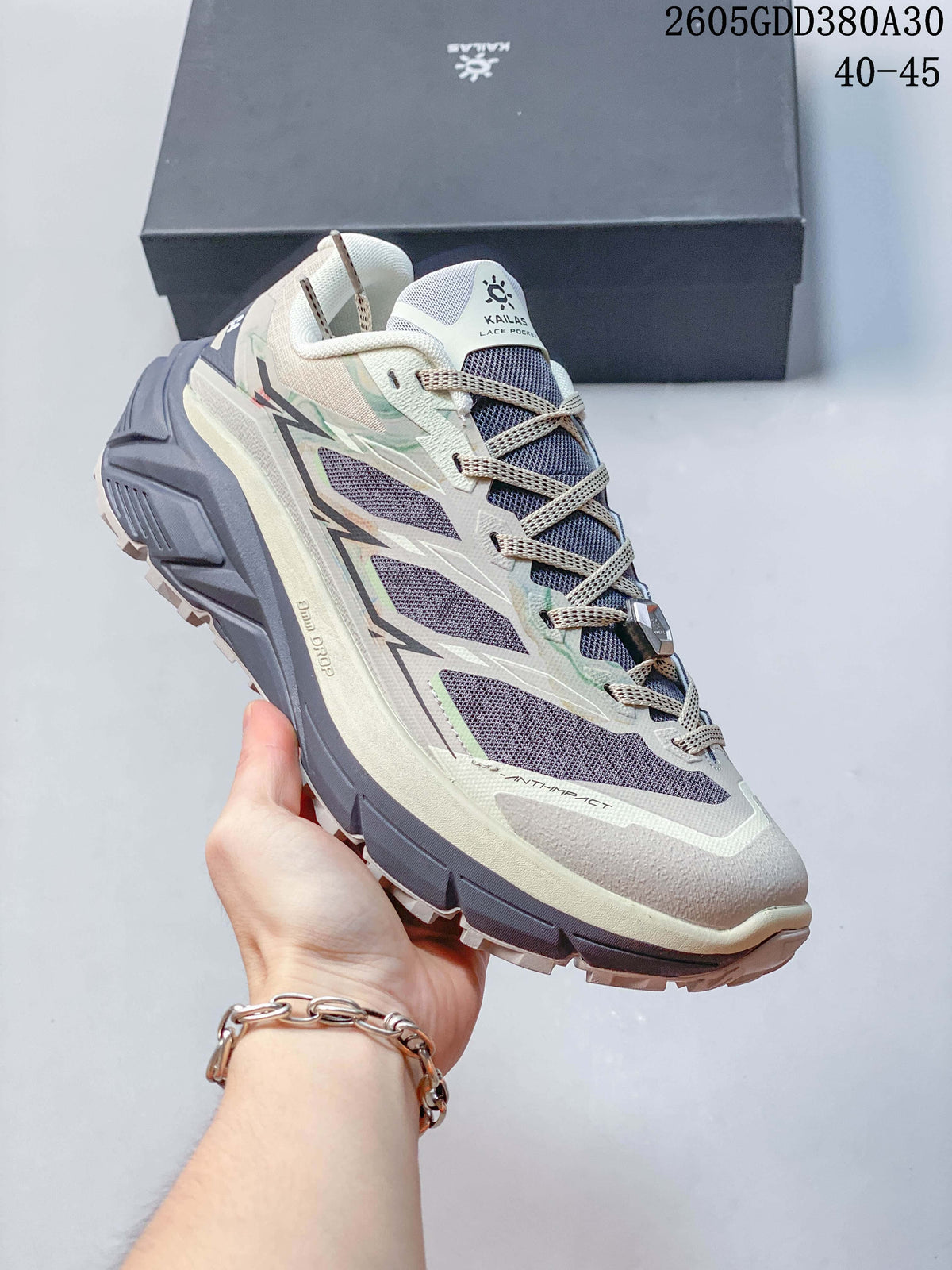 Angled side view of the trail shoe with purple-gray panels and lugged outsole