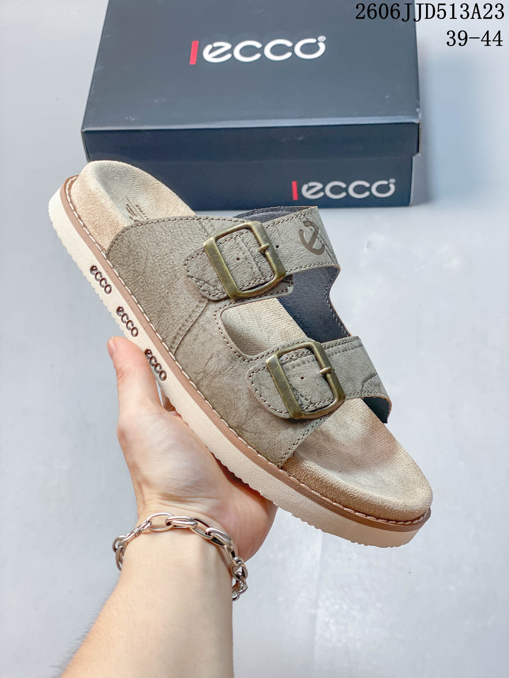 Close-up of a taupe slide sandal with two buckle straps