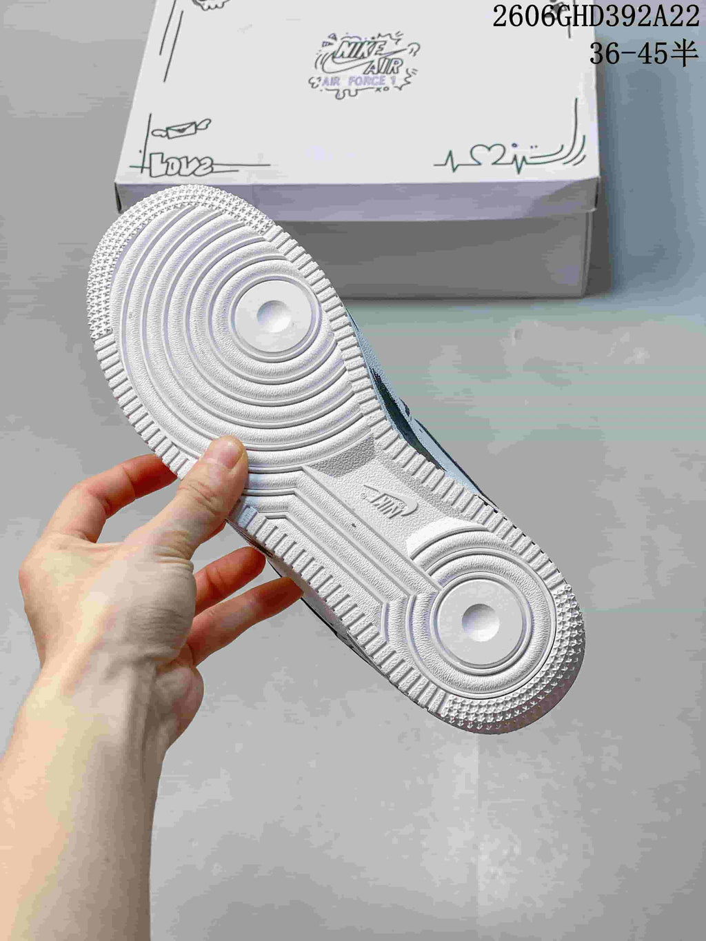 Bottom view of the white sneaker showing its circular tread pattern and textured outsole.