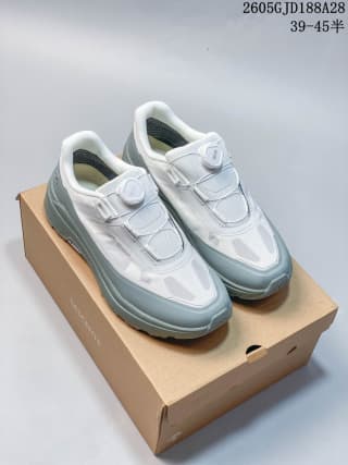 Pair of white and blue-gray low-top shoes with dial-style fastenings, displayed on a shoe box.