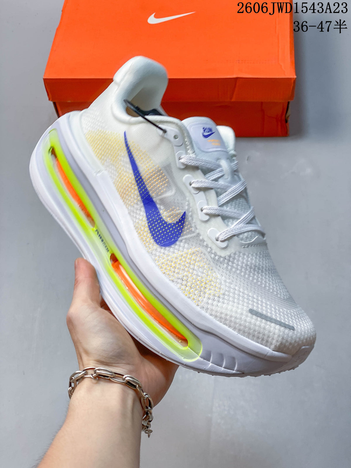 Angled side view showing the white upper, blue accent, and colorful sole