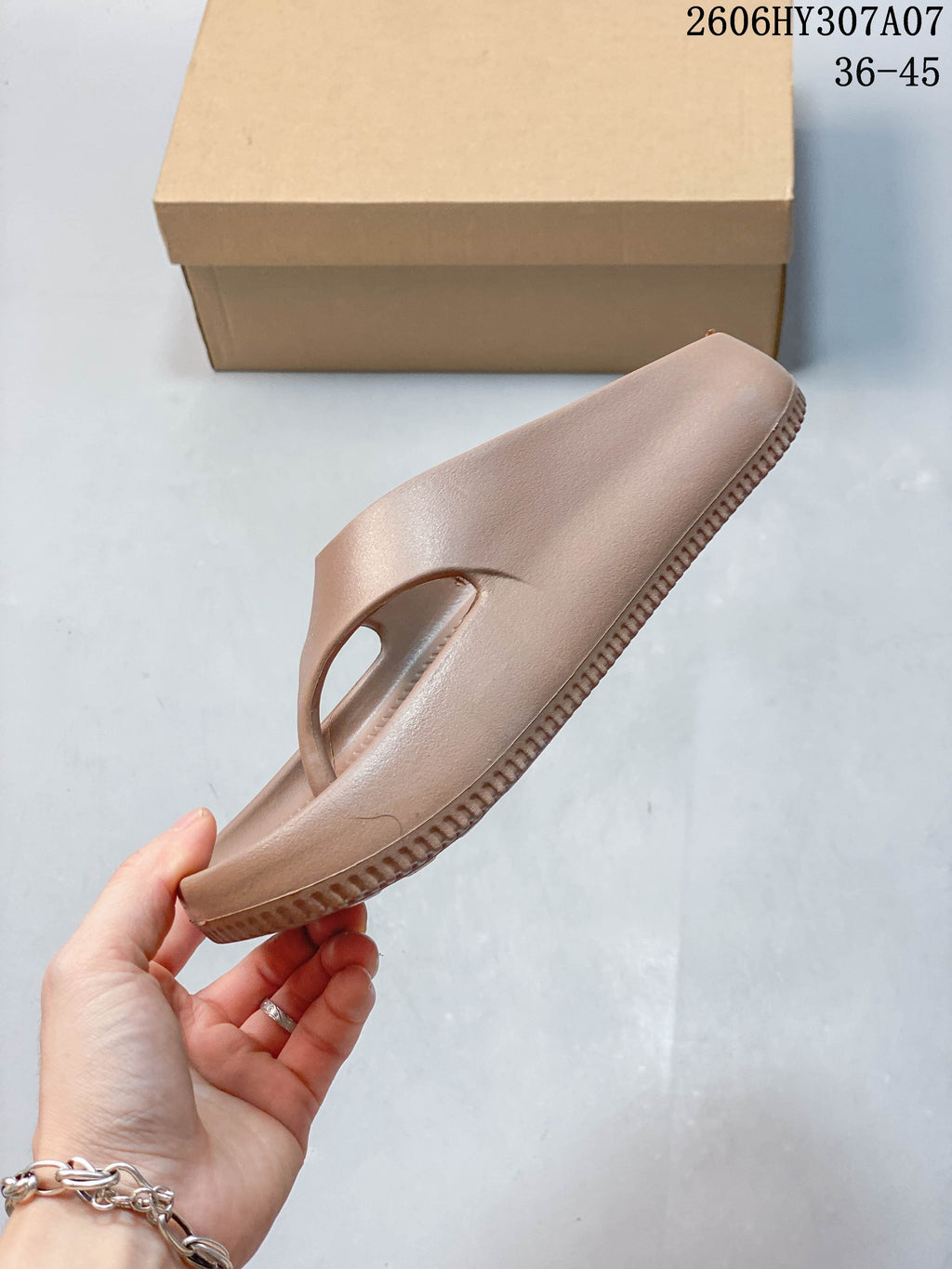 Side profile of a taupe thong-style slide sandal; image overlay shows sizes 36–45 and style code 2606HY307A07.