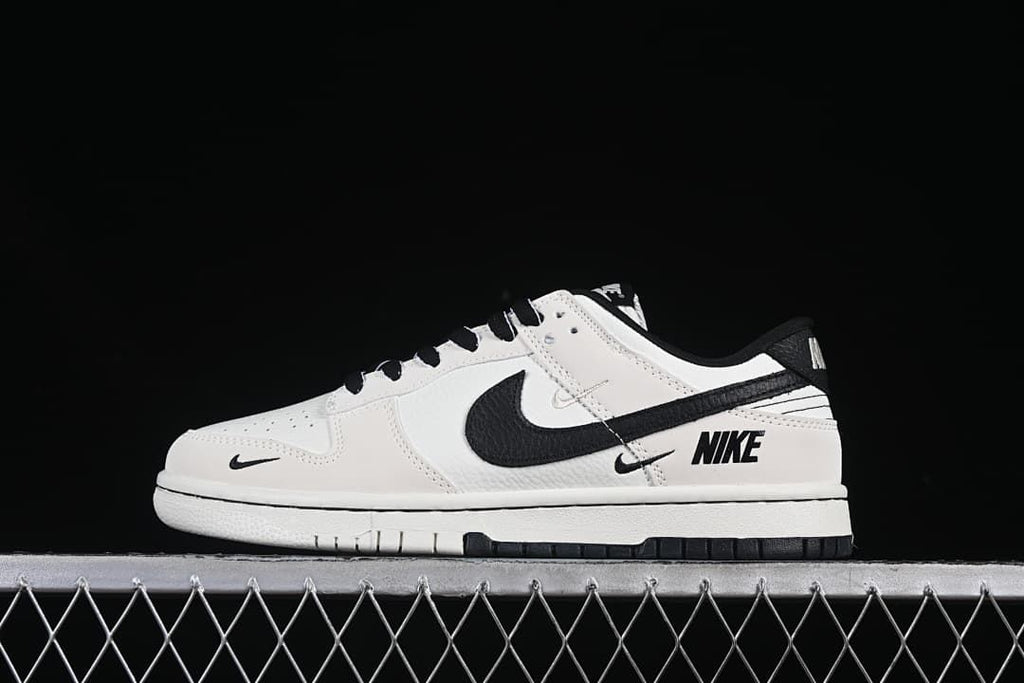 Side view of a white and black Nike SB Dunk Low sneaker with contrasting Swoosh details.