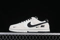 Side view of a white and black Nike SB Dunk Low sneaker with contrasting Swoosh details.