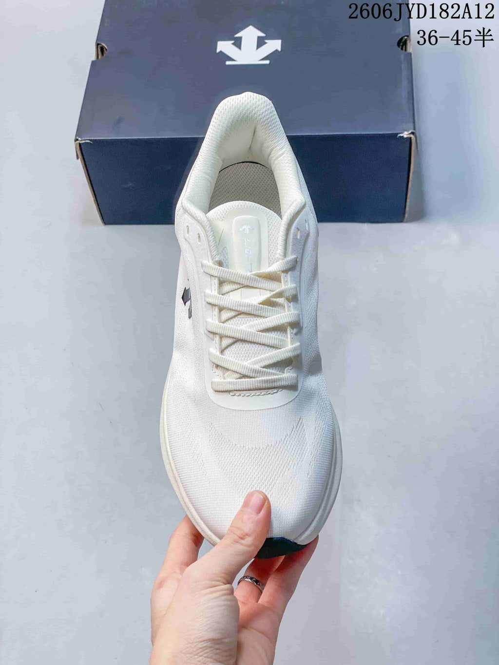 Top view of the white sneaker showing its laces, tongue, and textured toe.