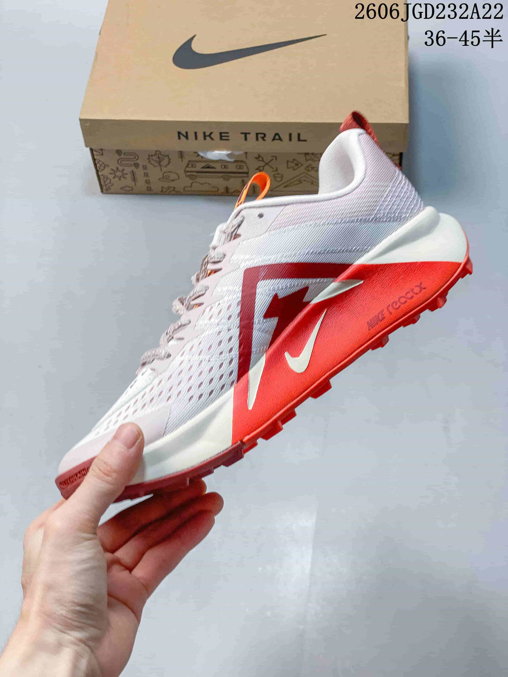 Side view of the light-colored Nike Wildhorse 10 with orange accents and trail outsole.