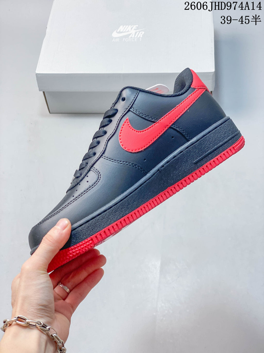 Side view showing red Swoosh-style panel and red outsole on a navy low-top sneaker
